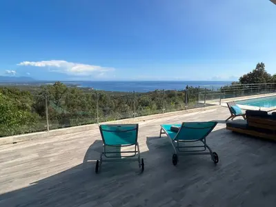 two chairs sitting on a deck next to a swimming pool at a STELLA DI FOCE in Kamiesch