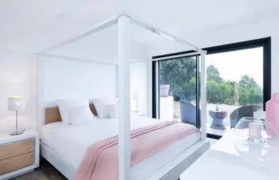 a white bedroom with a bed with a canopy at a STELLA DI FOCE in Kamiesch