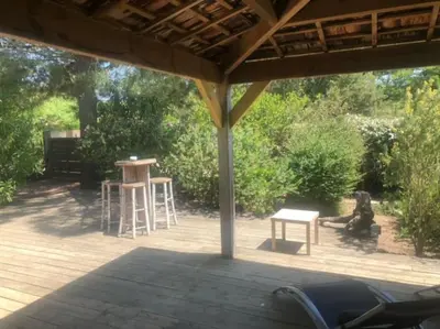 a patio with a table and stools in a yard at Villa à Cala-Rossa,Porto-Vecchio proche des plages in Le Ranch