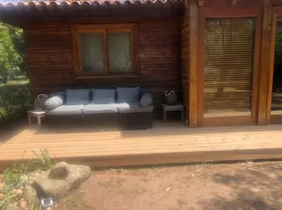 a couch sitting on a deck in a cabin at Villa à Cala-Rossa,Porto-Vecchio proche des plages in Le Ranch