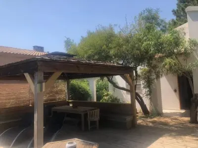a wooden pergola with a bench in a yard at Villa à Cala-Rossa,Porto-Vecchio proche des plages in Le Ranch