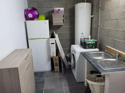 a small kitchen with a sink and a refrigerator at Charmante villa avec jardin in Prunete