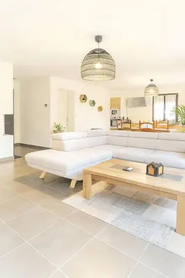 a living room with a white couch and a coffee table at Charmante villa avec jardin in Prunete