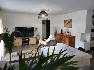 a living room with a couch and a flat screen tv at Charmante villa avec jardin in Prunete