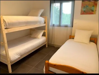 two bunk beds in a room with a window at Charmante villa avec jardin in Prunete