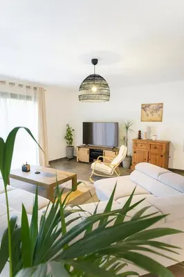 a living room with a couch and a tv at Charmante villa avec jardin in Prunete