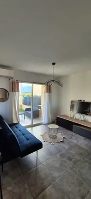 a living room with a blue couch and a table at Charmant appartement in Borgo