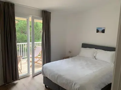a bedroom with a large bed and a balcony at Appartement en résidence privée in Le Ranch