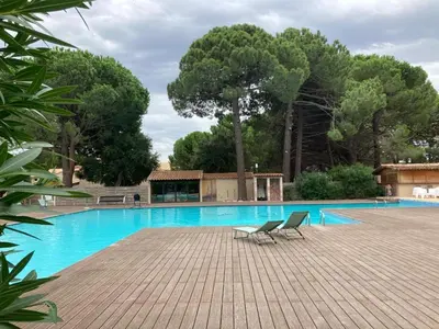 a large swimming pool with two chairs next to it at Appartement en résidence privée in Le Ranch