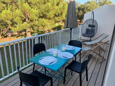 a blue table and chairs on a balcony at Appartement en résidence privée in Le Ranch
