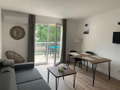 a living room with a couch and a table at Appartement en résidence privée in Le Ranch