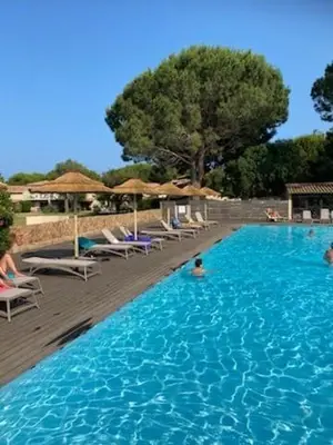 a large swimming pool with chairs and umbrellas in it at Appartement en résidence privée in Le Ranch