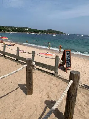 a beach with a fence and people in the water at Appartement en résidence privée in Le Ranch
