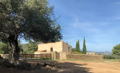 a building with a tree and a fence in front of it at Gîte Bergerie Saint Michel in Cateri