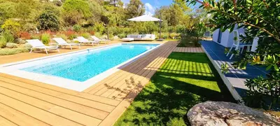 a backyard with a swimming pool and a wooden deck at Villa Alba, 8 pers, piscine chauffée, 5 minutes plage in Cirendinu