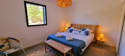 a bedroom with a bed with blue sheets and a window at Villa Alba, 8 pers, piscine chauffée, 5 minutes plage in Cirendinu