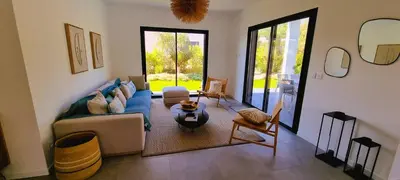 a living room with a couch and a table at Villa Alba, 8 pers, piscine chauffée, 5 minutes plage in Cirendinu