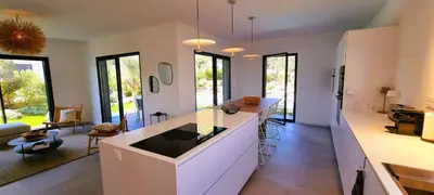 a large kitchen with a counter and a living room at Villa Alba, 8 pers, piscine chauffée, 5 minutes plage in Cirendinu