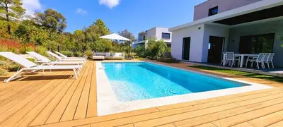 a backyard with a swimming pool and chairs and a house at Villa Alba, 8 pers, piscine chauffée, 5 minutes plage in Cirendinu