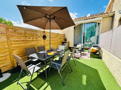a table and chairs with an umbrella on a lawn at Casa Tania in Borgo