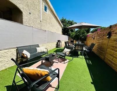a patio with chairs and tables and an umbrella at Casa Tania in Borgo