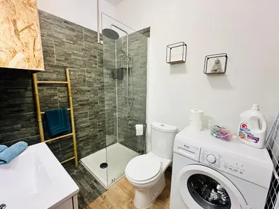 a bathroom with a toilet and a shower and a washing machine at Casa Tania in Borgo