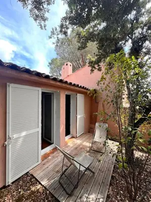 a wooden deck with a chair on top of a house at Logement Mésange600m à pied de SantaGiulia Jacuzzi in Porto-Vecchio