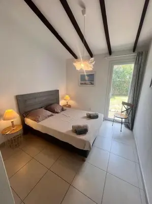 a bedroom with a large bed and a window at Logement Linotte, 600m à pied Santa Giulia Jacuzzi in Bocca del Oro