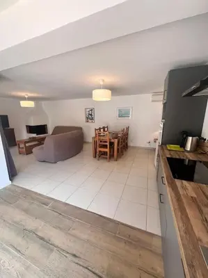 a living room with a couch and a table at Logement Linotte, 600m à pied Santa Giulia Jacuzzi in Bocca del Oro