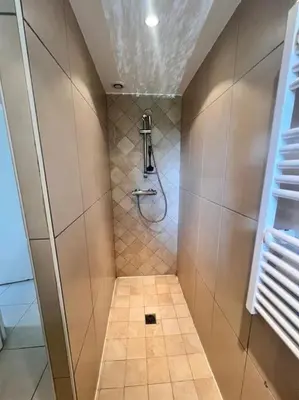a bathroom with a shower and a tile floor at Logement Linotte, 600m à pied Santa Giulia Jacuzzi in Bocca del Oro