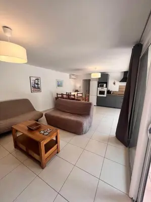 a living room with a couch and a coffee table at Logement Linotte, 600m à pied Santa Giulia Jacuzzi in Bocca del Oro