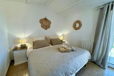 a bedroom with a bed with a night stand and a window at Adorable duplex vue mer 5 min à pied de Santa Giulia in Porto-Vecchio