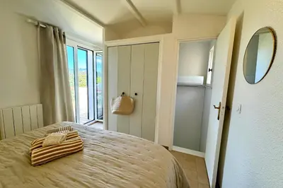 a bedroom with a bed with a mirror and a window at Adorable duplex vue mer 5 min à pied de Santa Giulia in Porto-Vecchio