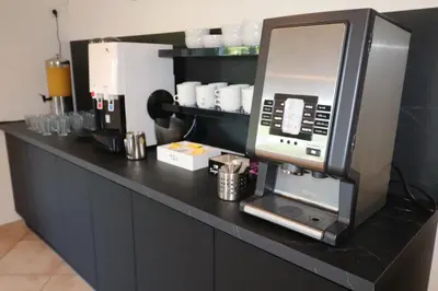 a black counter with a coffee machine on it at Hôtel Padolo in Bonifacio