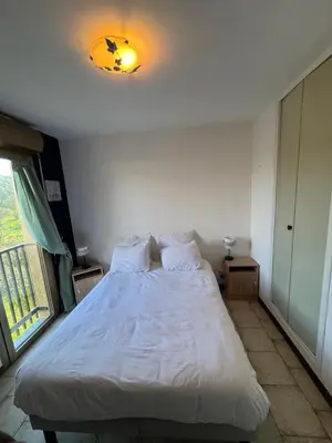 a bedroom with a white bed with a light on the ceiling at Vacances AJACCIO in Ajaccio