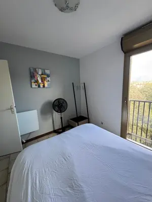 a bedroom with a white bed and a window at Vacances AJACCIO in Ajaccio