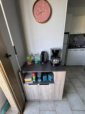 a clock on a wall next to a kitchen at Vacances AJACCIO in Ajaccio