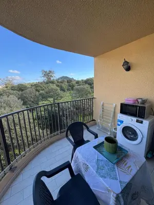 a balcony with a washing machine and a table and chairs at Vacances AJACCIO in Ajaccio