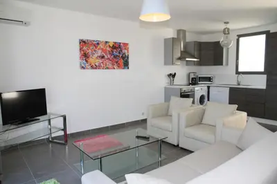 a living room with a white couch and a tv at Résidence Isola Hotel in Borgo