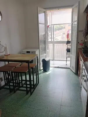 a kitchen with a table and chairs and a balcony at Chambres chez l'habitant in Ajaccio