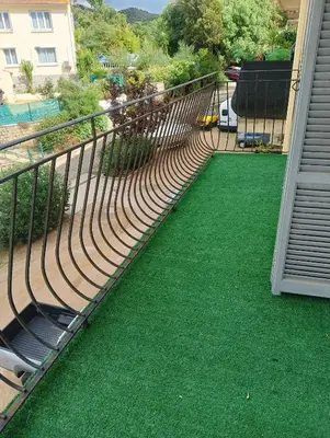 a balcony with green grass and a railing at Chambres chez l'habitant in Ajaccio