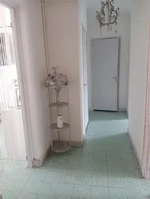 a hallway with a green tile floor and a door at Chambres chez l'habitant in Ajaccio