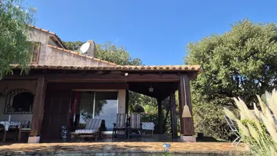 a porch of a house with chairs and a table at Villa Nitiola Plage de Palombaggia in Bocca del Oro