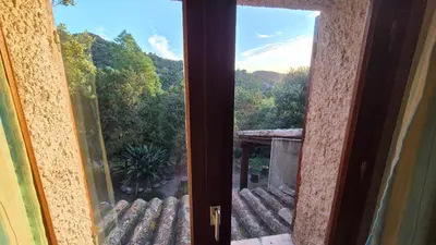 an open window with a view of a garden at Villa Nitiola Plage de Palombaggia in Bocca del Oro