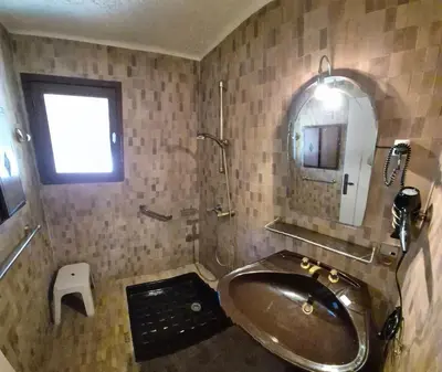 a bathroom with a tub and a mirror and a sink at Villa Nitiola Plage de Palombaggia in Bocca del Oro