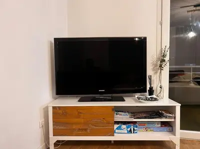 a flat screen tv on a white entertainment center at CASA NINA FURIANI CORSE Appartement en résidence in Paterno