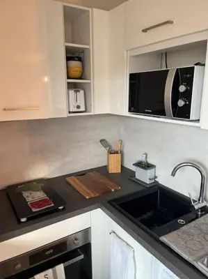 a kitchen counter with a sink and a microwave at CASA NINA FURIANI CORSE Appartement en résidence in Paterno