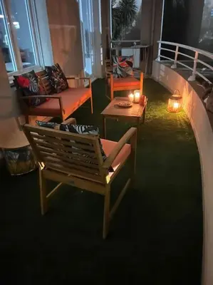 a balcony with two chairs and a table with candles at CASA NINA FURIANI CORSE Appartement en résidence in Paterno