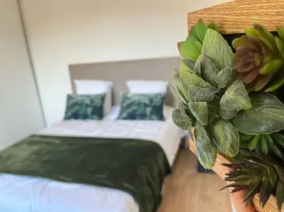 a bedroom with two beds and a potted plant at CASA NINA FURIANI CORSE Appartement en résidence in Paterno