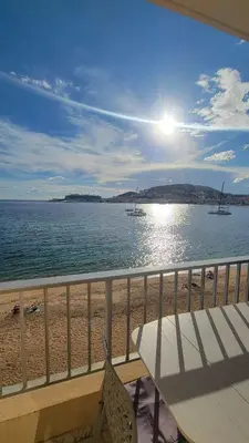 a balcony with a table and chairs on the beach at La plage à vos pieds, magnifique vue sur Ajaccio, pour 2 personnes in Ajaccio